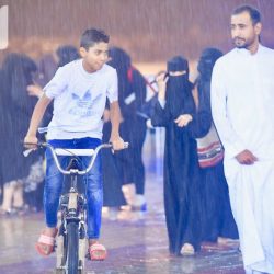 رجل أمن يحمي أُمًّا وأطفالها في دورية من الأمطار الغزيرة بجازان
