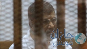 Egypt's deposed Islamist president Mohamed Morsi, charged along with 130 others of plotting attacks and escaping from prison in 2011, sits inside the defendants cage during his trial at the police academy in Cairo on August 18, 2014. Morsi and several leaders from his Muslim Brotherhood have been put on trial on charges that could lead to the death penalty. AFP PHOTO / STR (Photo credit should read STR/AFP/Getty Images)